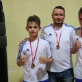 Medaliści z Boxing Teamu Chojnice z trenerem. Od lewej: Igor Stefaniak, Marcin Gruchała i Dominik Dul. Fot. Wojciech Piepiorka